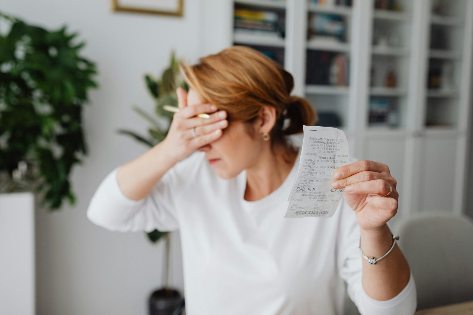 Frustrated woman holding a receipt, representing analysis of fixed and variable costs in business