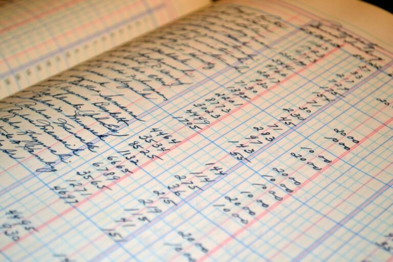 Open accounting ledger with handwritten financial entries showing columns of numbers and transactions